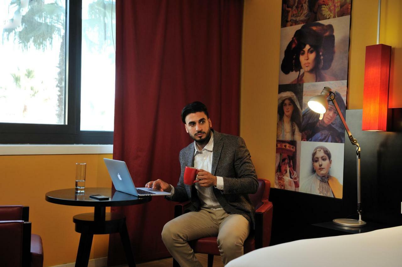 Hotel Mercure Alger Aeroport Dar el Beïda Eksteriør bilde A man working on a laptop